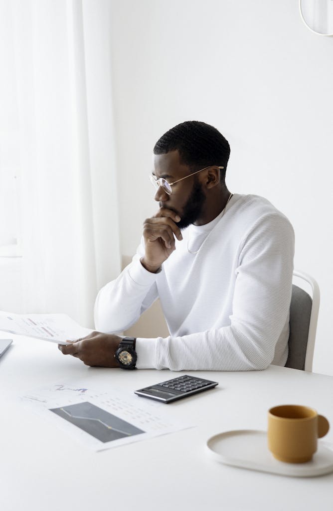 Photo Of Man Holding A White Paper - best areas to invest in property